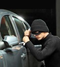 Thief with a mask trying to steal an automobile